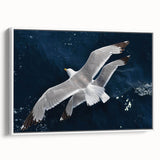 Framed canvas wall art featuring a serene sea birds design in soft pastel colors, showcasing a white frame and side view perspective, ideal for coastal decor.