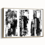 Framed black and white abstract wall art featuring geometric shapes and bold lines, accented with a gold frame, ideal for modern decor.