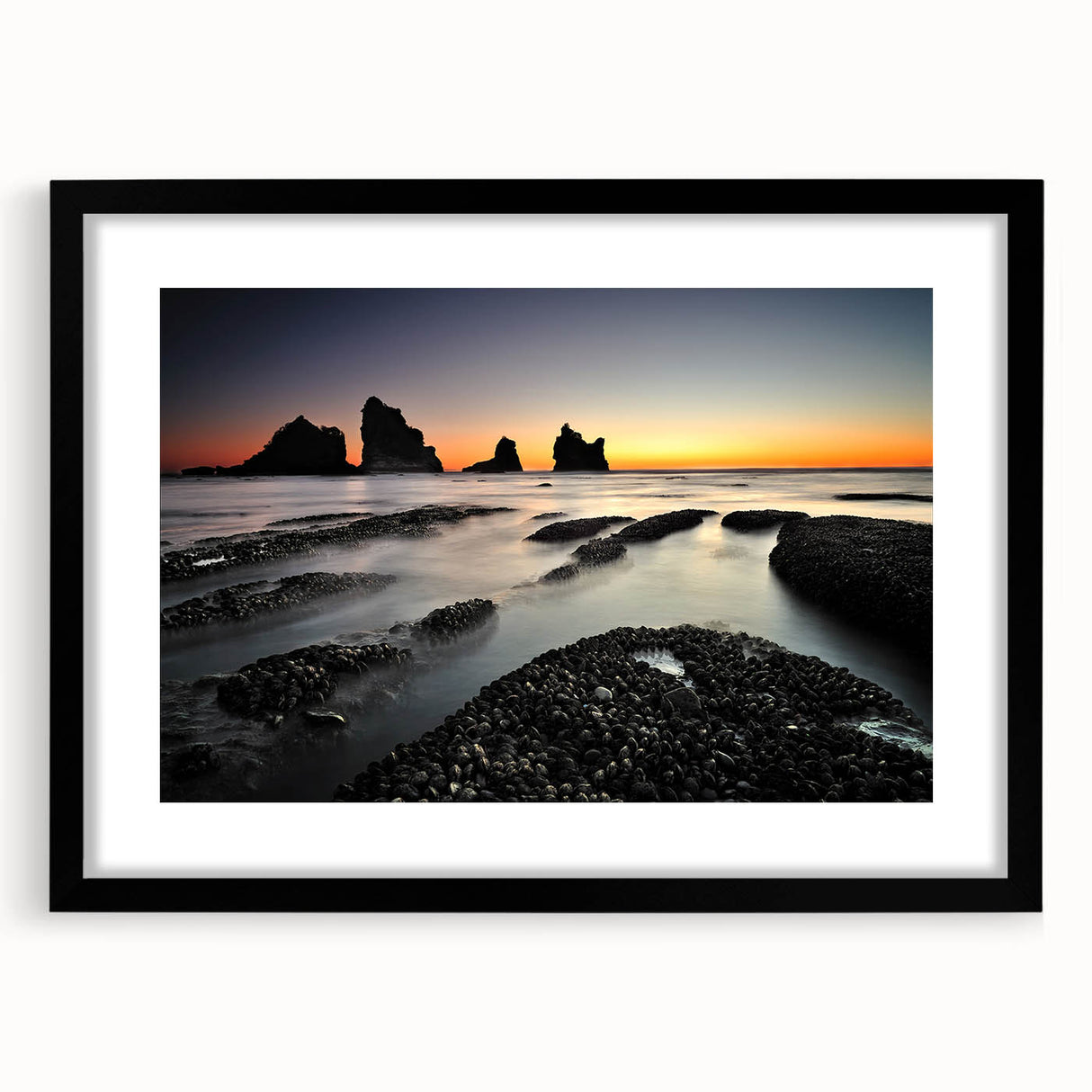 Colorful abstract art print of New Zealand's West Coast in vibrant blue and green hues, framed in black.