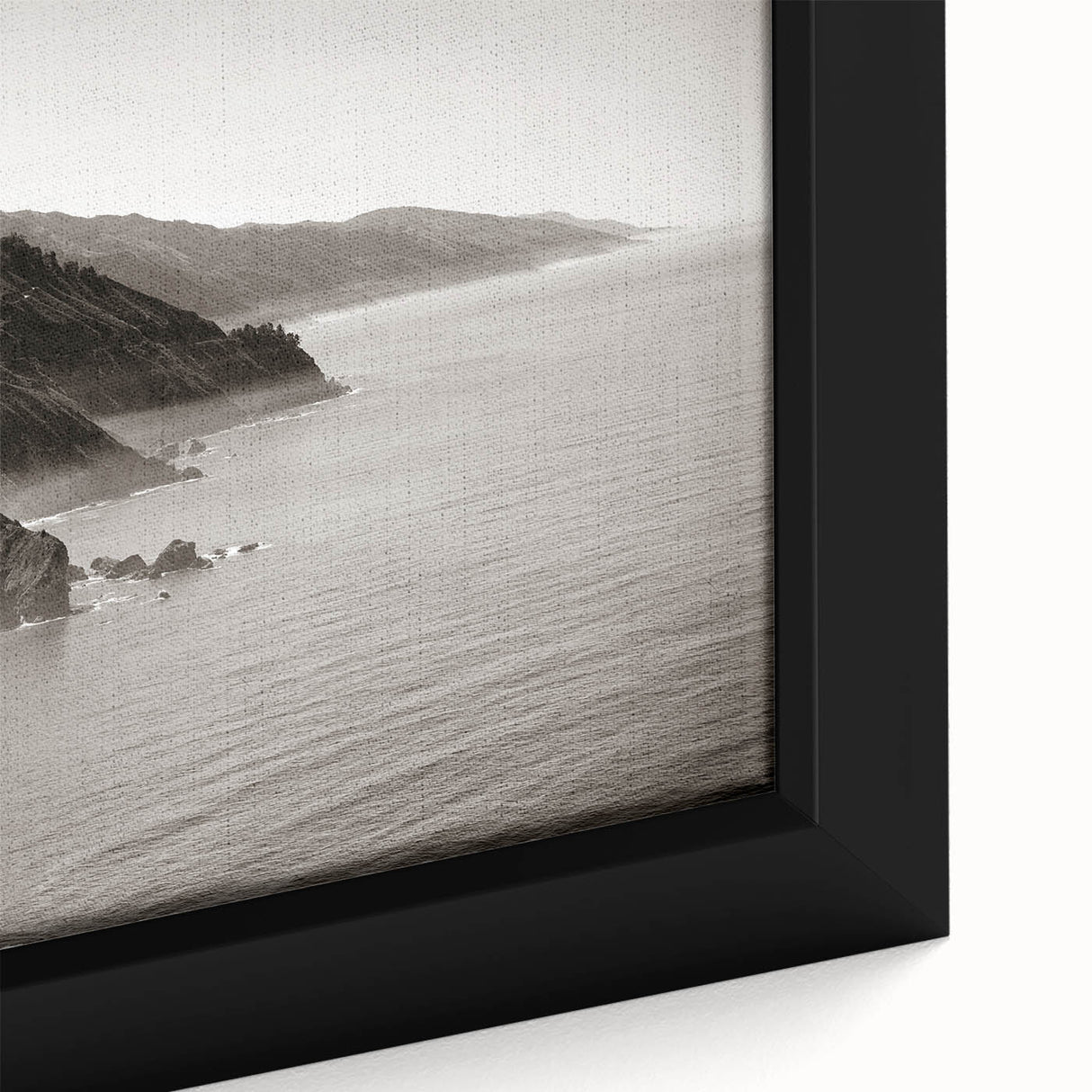 Close-up of textured black wall art depicting the Big Sur coastline in vibrant colors on a framed canvas.