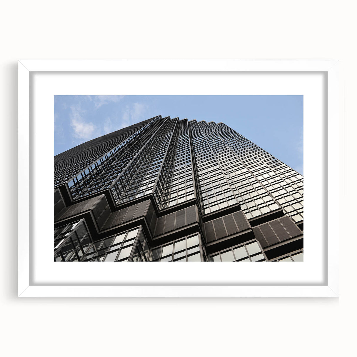 Abstract art print of Minneapolis skyline in muted gray and blue tones, framed with a white mat.