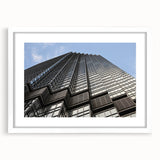 Abstract art print of Minneapolis skyline in muted gray and blue tones, framed with a white mat.