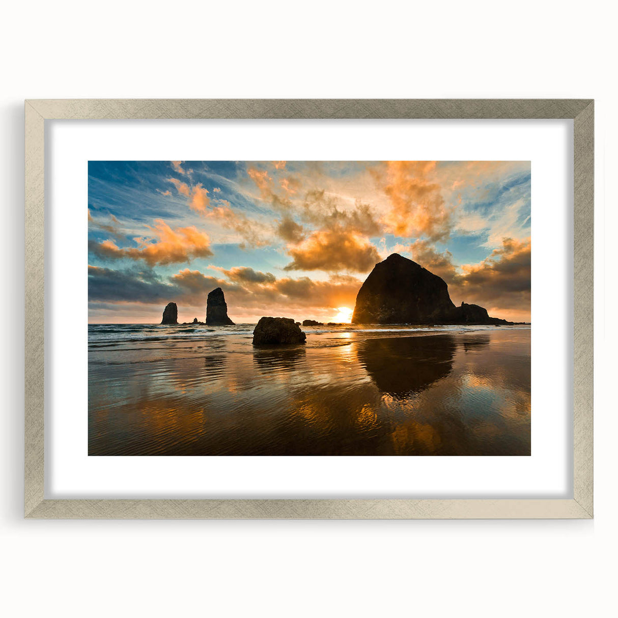 Textured art print of Cannon Beach, Oregon, in muted blue and gray tones on a framed silver mat, suitable for bedroom decor.