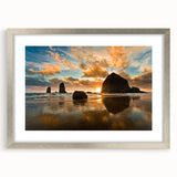 Textured art print of Cannon Beach, Oregon, in muted blue and gray tones on a framed silver mat, suitable for bedroom decor.
