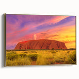 Framed canvas depicting Ayers Rock in Australia, featuring earthy tones and a vintage poster style.