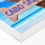 Art deco poster of Cabo San Lucas scenery on rolled canvas, with vibrant blue and white tones.
