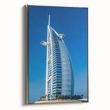 Framed canvas wall art featuring the Burj Al Arab with a vintage poster style in black and gold tones.