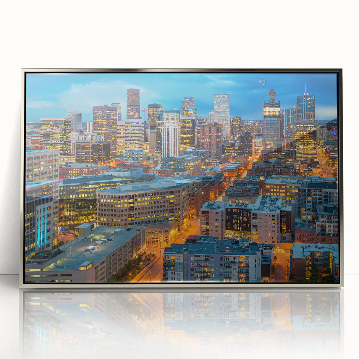Mid-century modernist art depicting the Denver skyline in muted gray and blue tones, framed in silver acrylic.