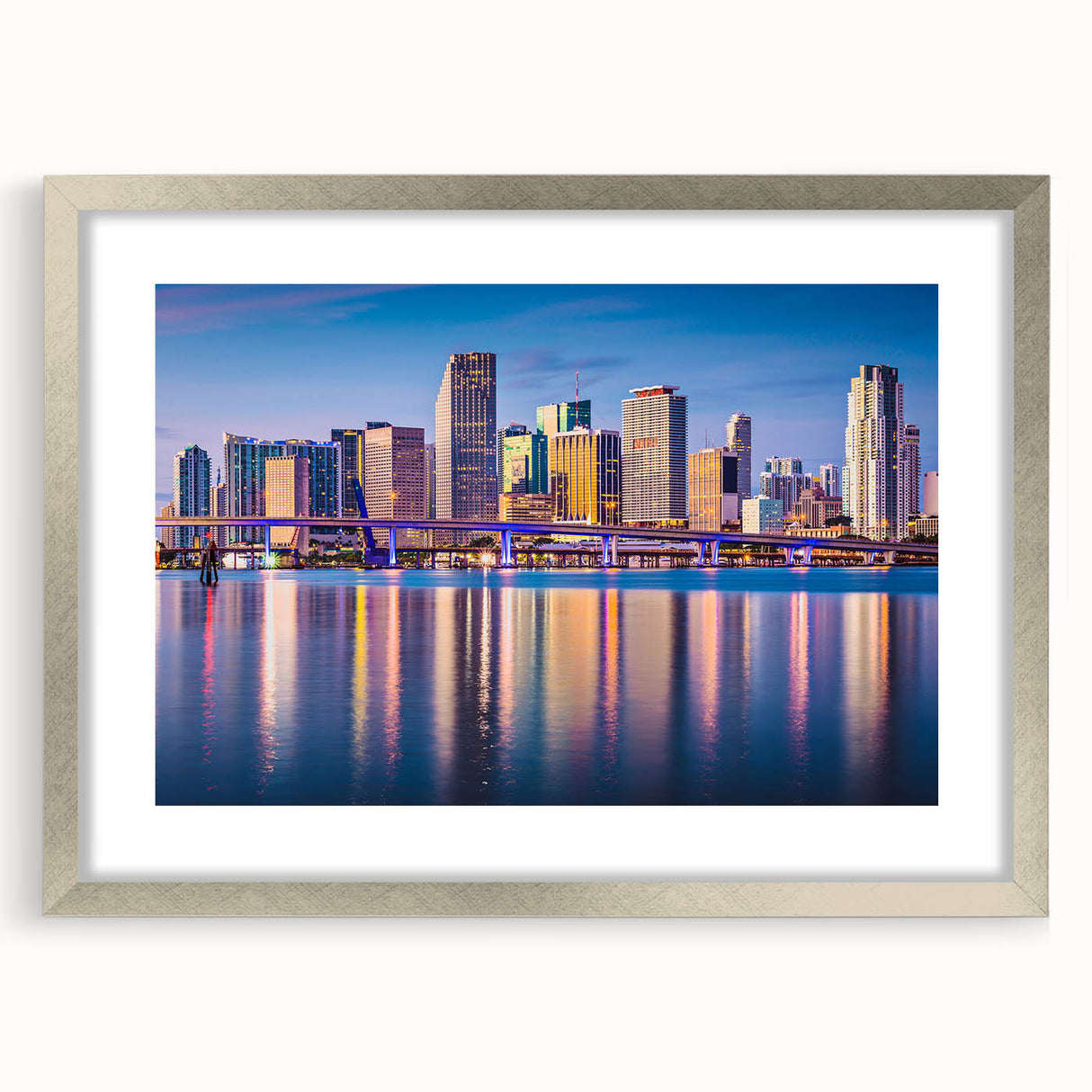 Textured art print of an abstract Miami skyline in muted blue and gray tones, framed in silver, ideal for bedroom decor.