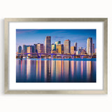 Textured art print of an abstract Miami skyline in muted blue and gray tones, framed in silver, ideal for bedroom decor.