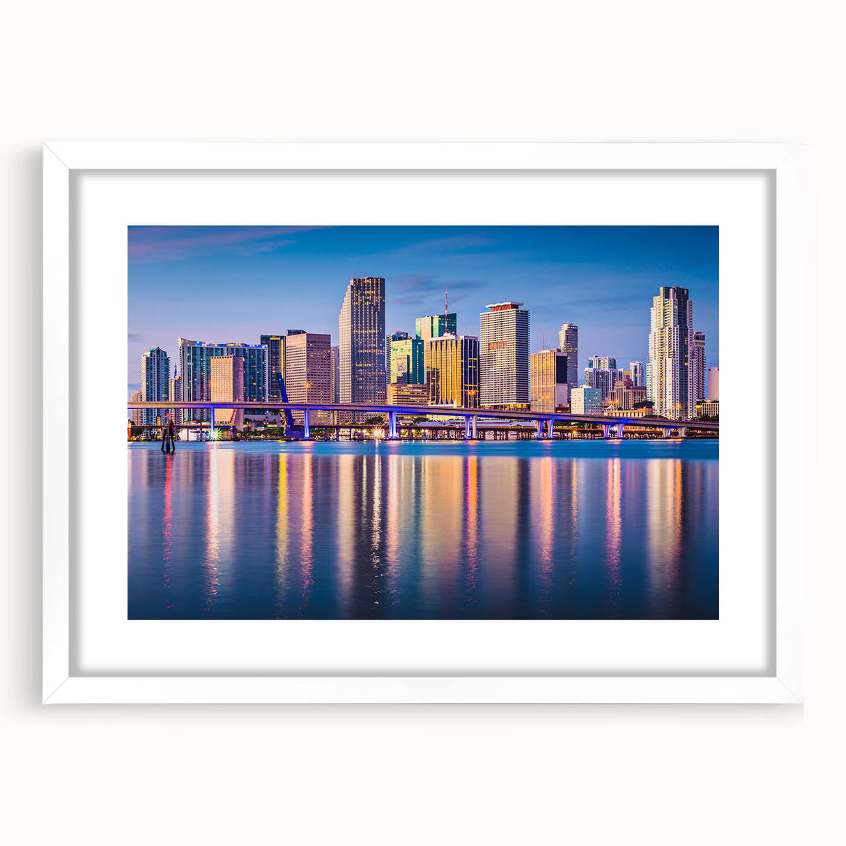 Abstract art print of Miami skyline in muted blue and pink tones on a white framed canvas, ideal for dining room decor.