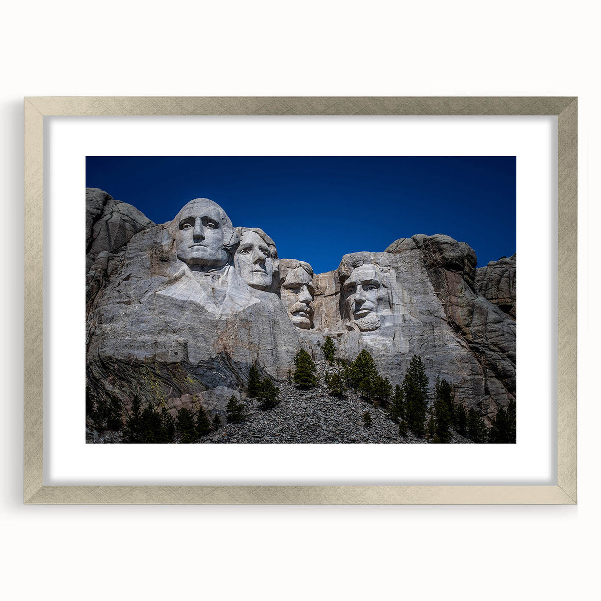 Textured art print of Mt. Rushmore in muted earth tones on a silver-framed mat, suitable for bedroom decor.