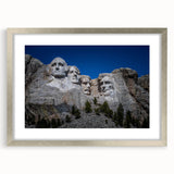 Textured art print of Mt. Rushmore in muted earth tones on a silver-framed mat, suitable for bedroom decor.