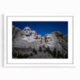 Abstract art print of Mt. Rushmore in muted earth tones on a framed white mat, suitable for dining room decor.