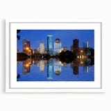 Abstract art print of Houston skyline in muted gray and blue tones on a framed white mat, suitable for dining room decor.