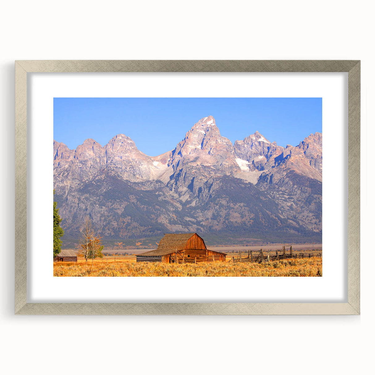 Textured art depicting the Grand Tetons in muted earth tones on a framed silver mat, suitable for bedroom decor.