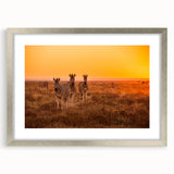 Abstract art print of an African scenery in muted earth tones on a framed silver mat, ideal for dining room decor.