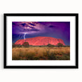 Abstract art print of Ayers Rock in vibrant orange and red hues on a black framed canvas, suitable for living room decor.