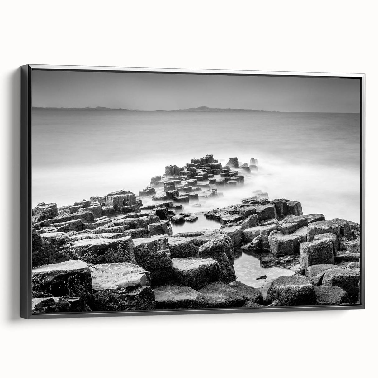 Black and white wall art featuring a vintage poster style landscape of Northern Ireland on a framed canvas.