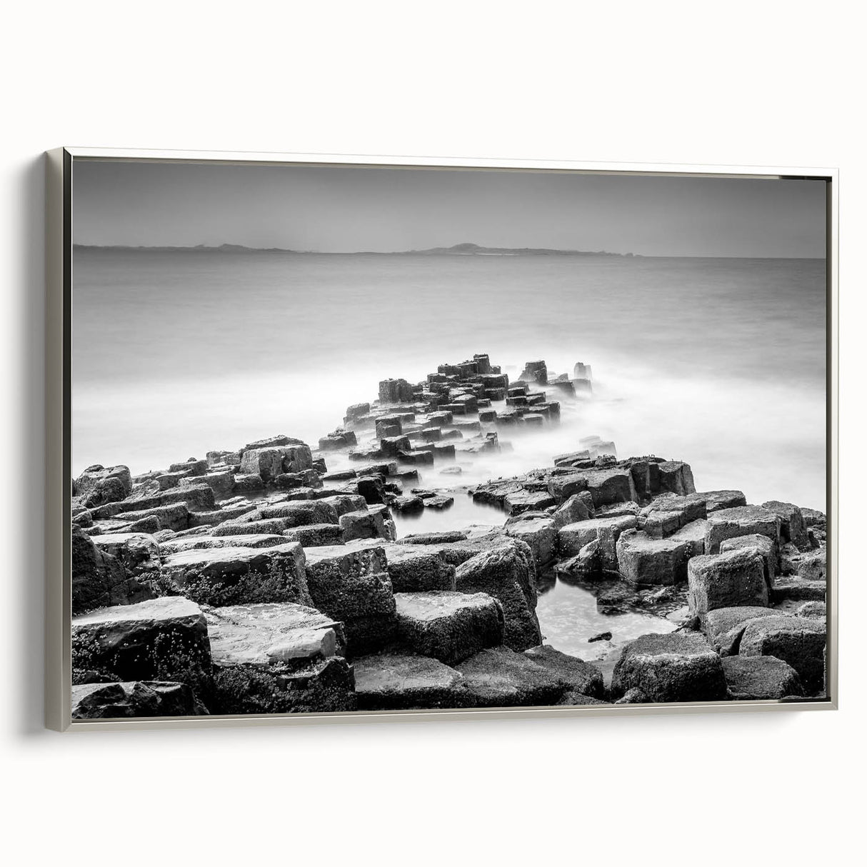 Framed canvas landscape art painting depicting the rugged coastline of Northern Ireland in muted earth tones.