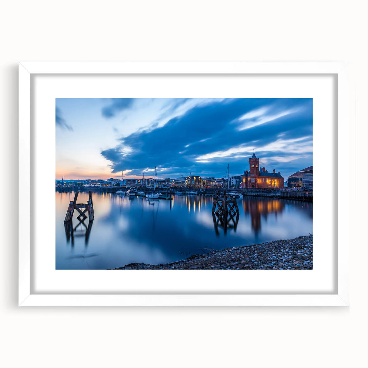 Abstract art print of a Welsh landscape in muted green and blue tones, framed with a white mat.