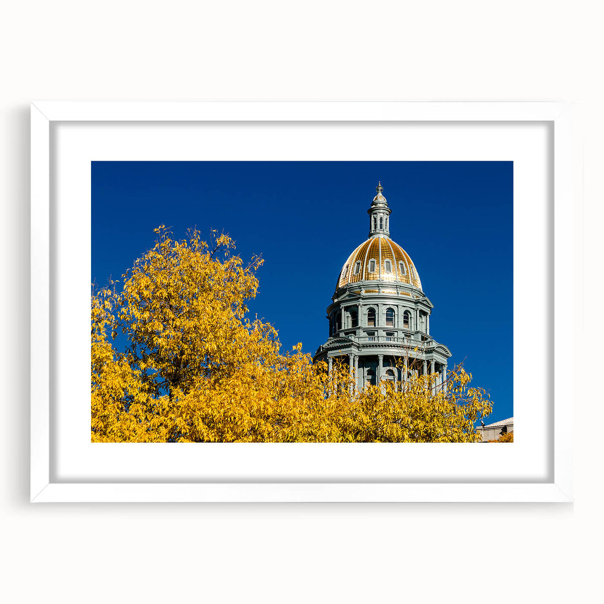 Abstract art print of Denver skyline in muted blue and gray tones on a white framed mat, ideal for dining room decor.