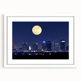 Abstract art print of Tampa skyline in muted blue and gray tones on a white framed mat, ideal for dining room decor.