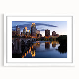 Abstract art print of Minneapolis skyline in muted gray and blue tones on a framed white mat, ideal for dining room decor.