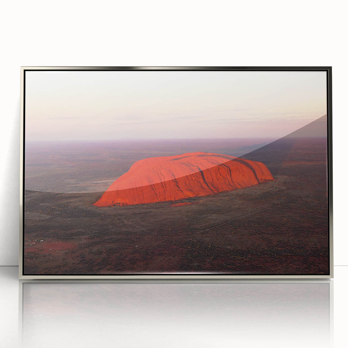 Acrylic print of Ayers Rock in silver frame, featuring earthy red and orange tones, suitable for modern art wall decor.
