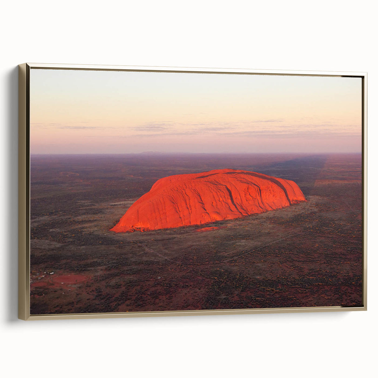 Framed canvas featuring a landscape art painting of Ayers Rock in Australia, with a palette of golden and black tones.