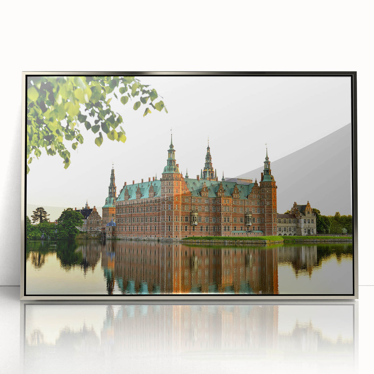 Large art print of a serene Danish landscape in muted green and blue tones, framed in silver acrylic.