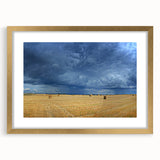 Abstract art print of a European scenery in muted gold and green tones, framed with a golden mat.