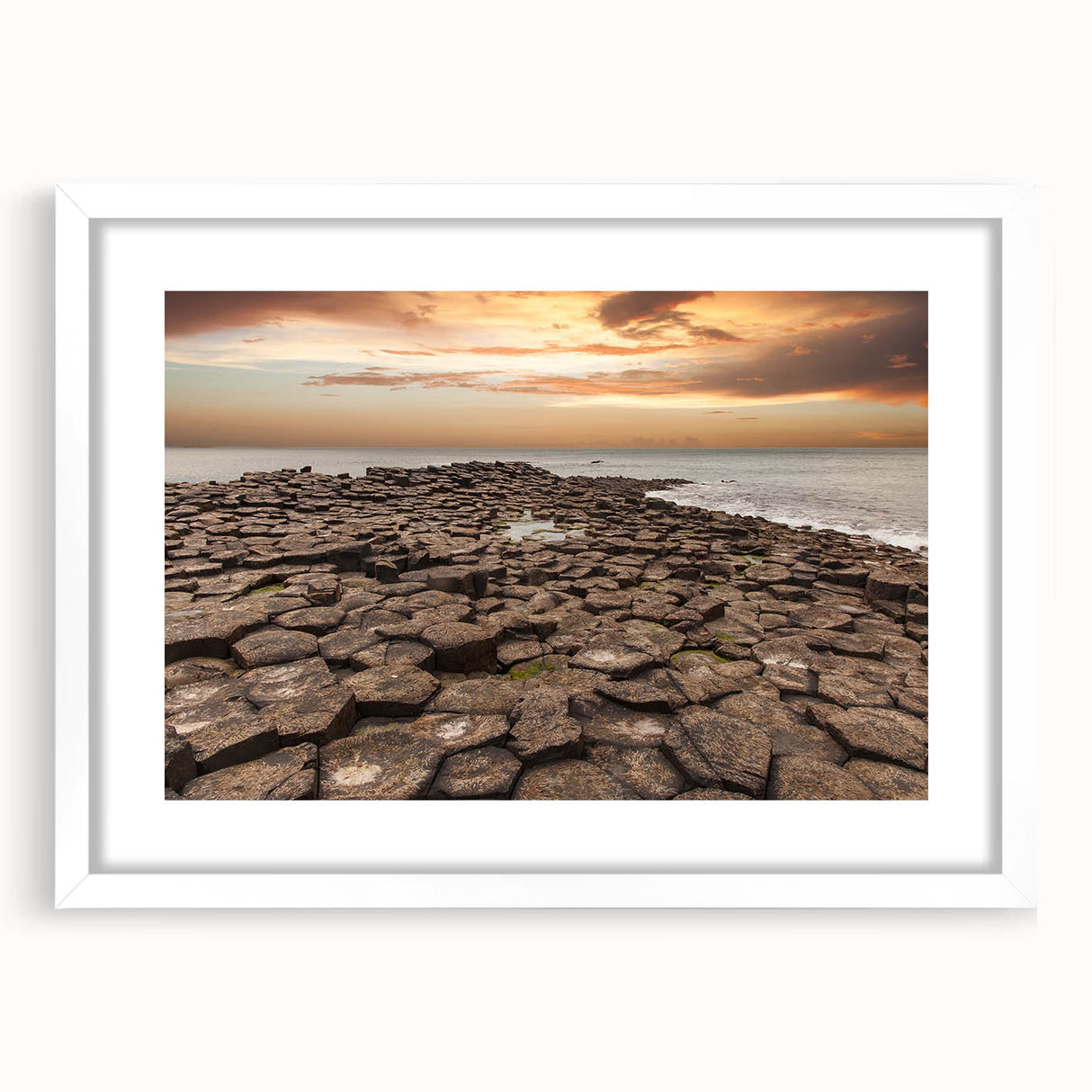 Textured abstract art print of a Northern Ireland scenery in muted green and blue tones on a framed white mat.
