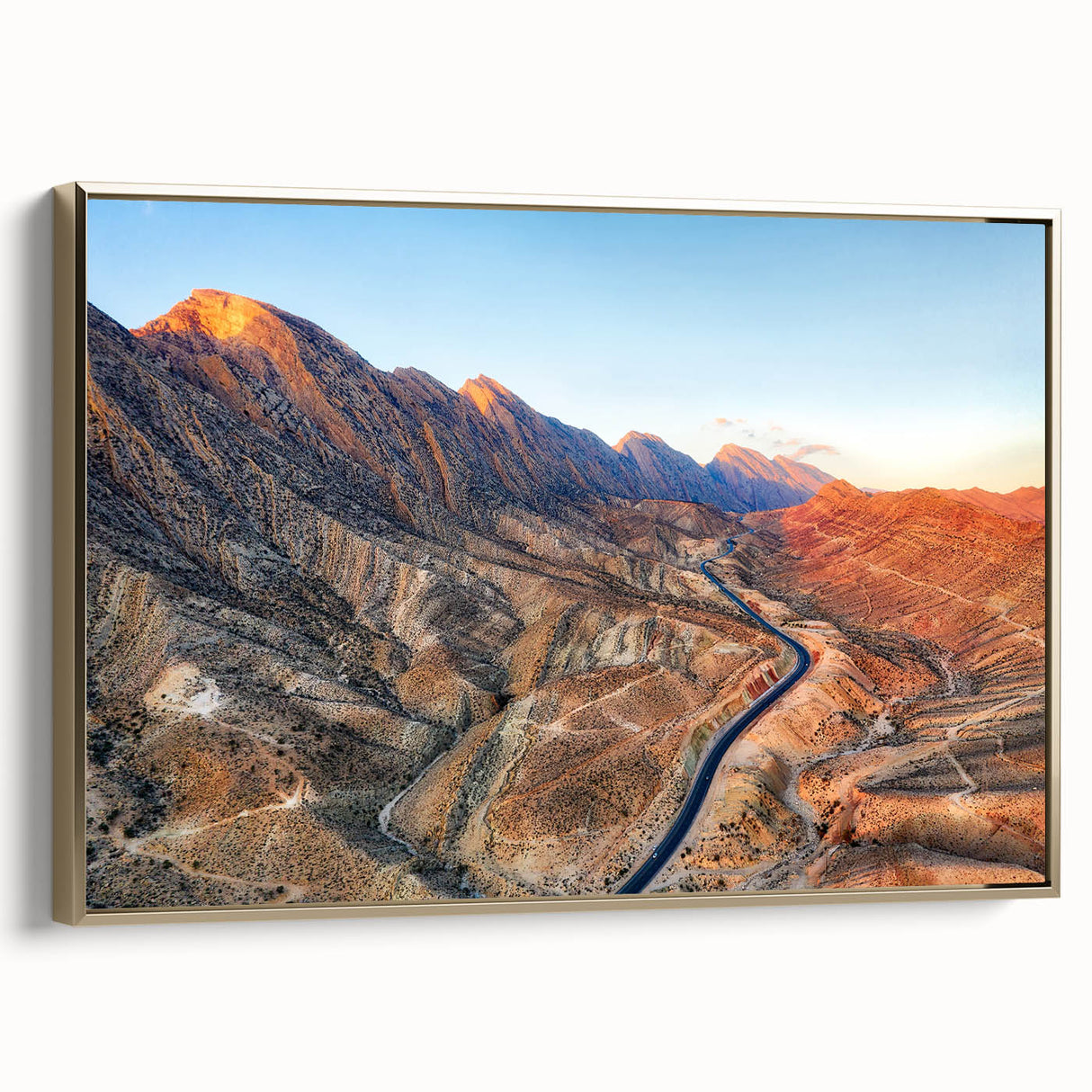 Framed canvas featuring a vintage-style landscape painting of a Middle Eastern scene in muted gold and black tones.