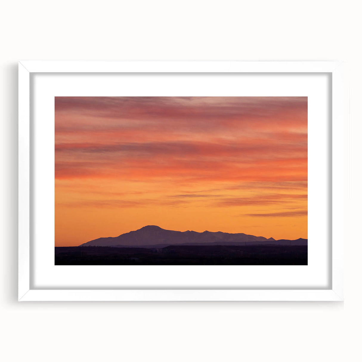 Abstract art print of Pikes Peak in muted blue and green tones, framed with a white mat, ideal for dining room decor.