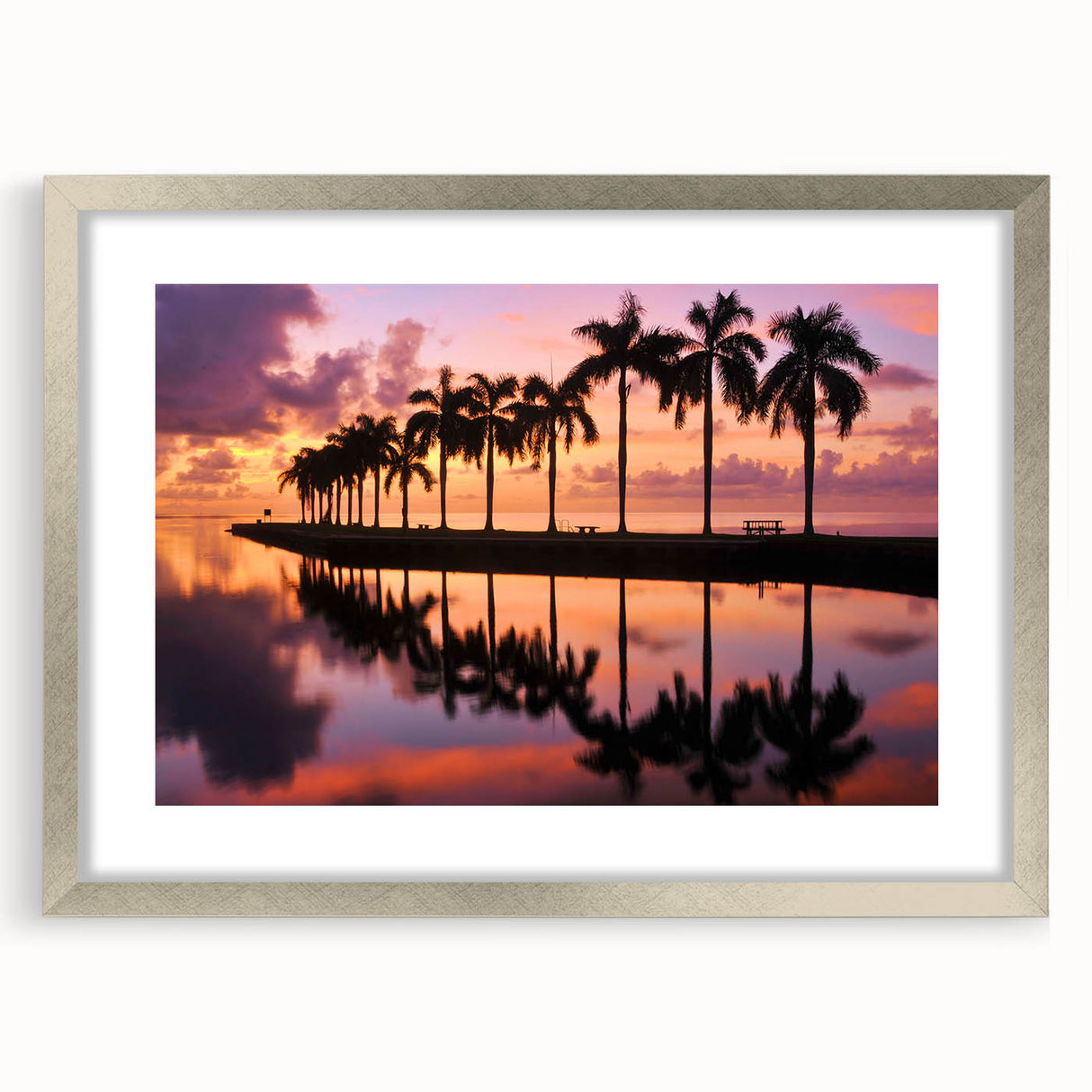Textured art print of abstract Miami scenery in muted blue and gray, framed in silver, ideal for bedroom ambiance.