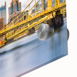 Large abstract wall art of Pittsburgh skyline in muted blue and gray tones on acrylic glass.