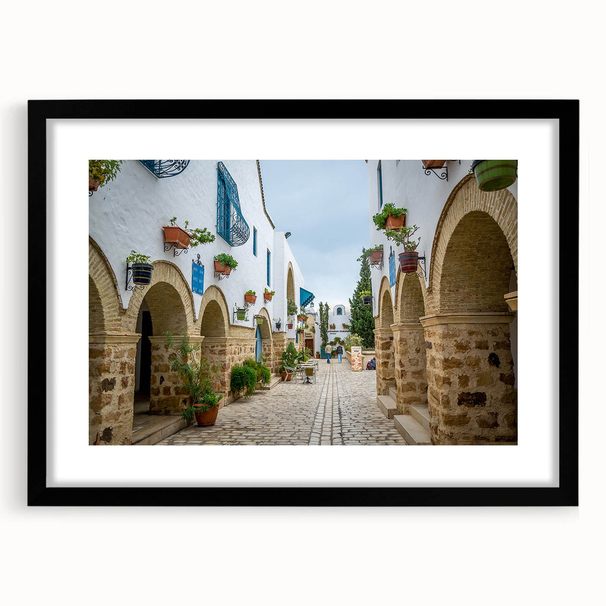 Abstract art print depicting colorful, textured scenery of Tunisia in a large black frame, ideal for living room decor.