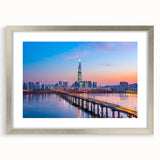 Textured art print of abstract Seoul skyline in muted grays and blues, framed in silver, ideal for bedroom decor.