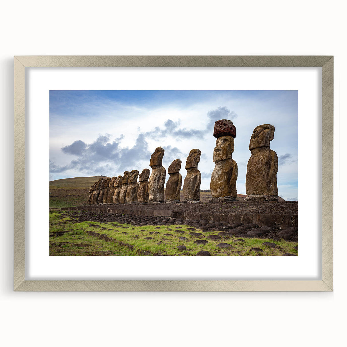 Textured art depicting Easter Island statues in muted earth tones on a framed silver mat, suitable for bedroom decor.