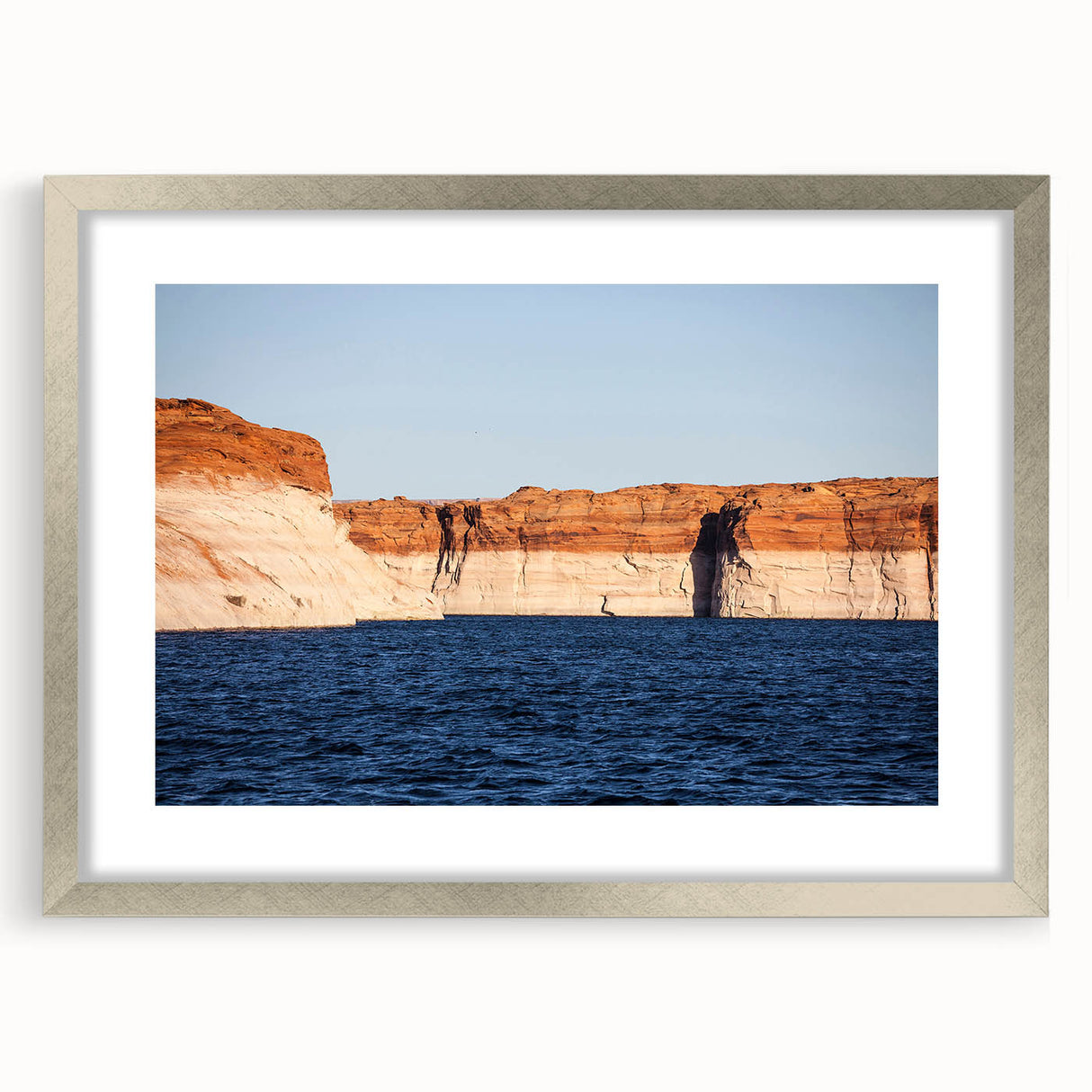 Textured art print of Lake Powell with abstract design in muted earth tones on a silver-framed mat, ideal for bedroom decor.