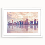 Abstract art print of Miami skyline in muted blue and pink tones on a framed white mat, ideal for dining room decor.