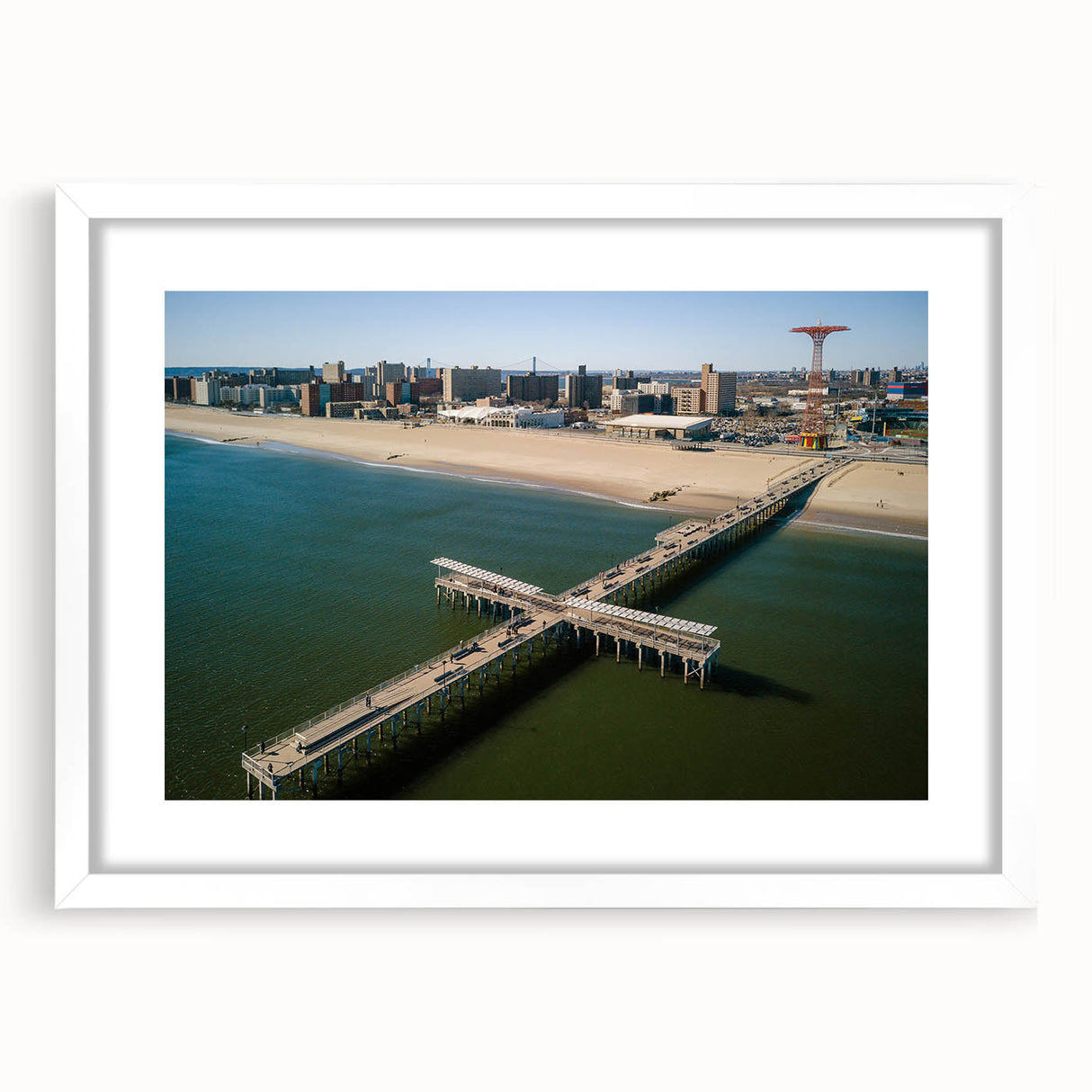 Abstract art print of Coney Island in muted blue and green tones on a white framed canvas, suitable for dining room decor.