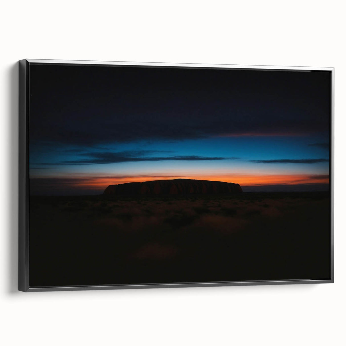 Black and white framed canvas of Ayers Rock landscape, ideal for bedroom decor.