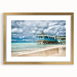 Abstract art print of Caribbean scenery in muted blue and green tones on a framed gold mat, ideal for dining room decor.