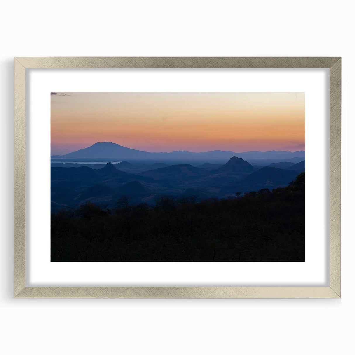 Textured abstract art print of a Central American landscape in muted earth tones, framed in silver, ideal for bedroom art.