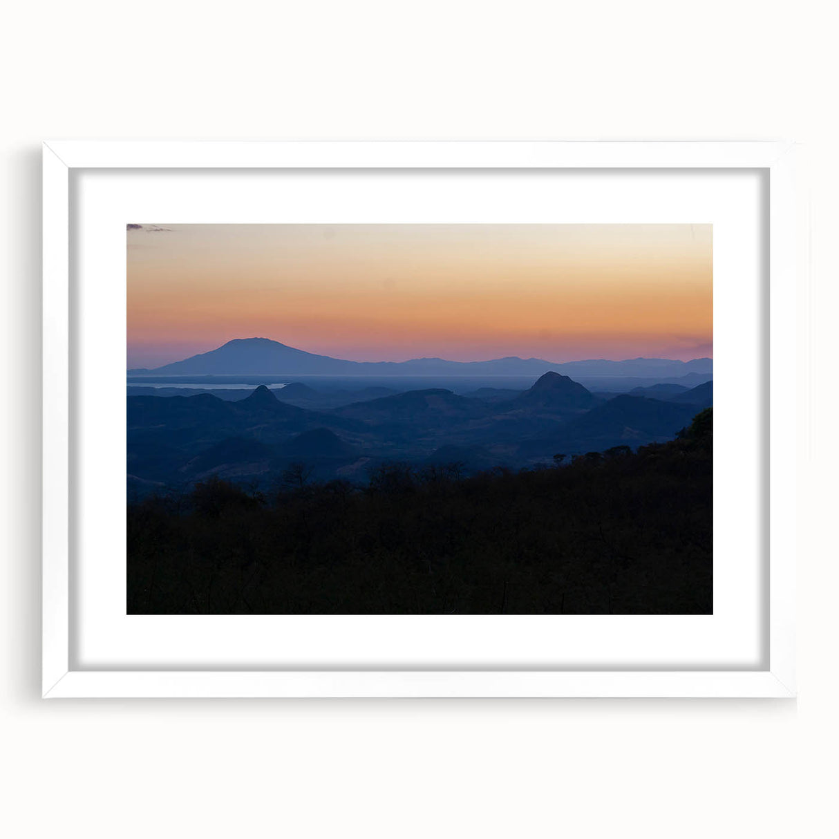 Abstract art print of Central American scenery in muted earth tones, framed with a white mat, suitable for dining room decor.