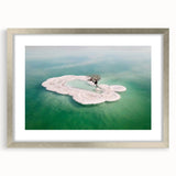 Textured abstract art print depicting the Dead Sea in muted blue and beige tones on a framed silver mat.