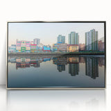 Mid-century modernist art depicting a cityscape in muted silver and blue tones on a framed acrylic.