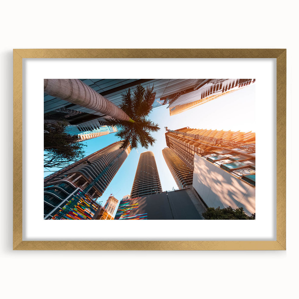 Extra large abstract art print of Miami skyline in textured gold frame, using vibrant sunset colors.